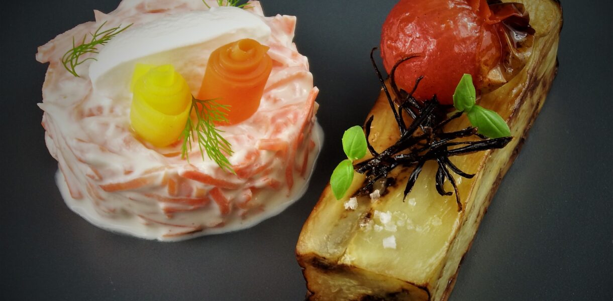 Kreative vegetarische Vorspeise mit Tomate, Käse und Gemüse-Dekoration.
