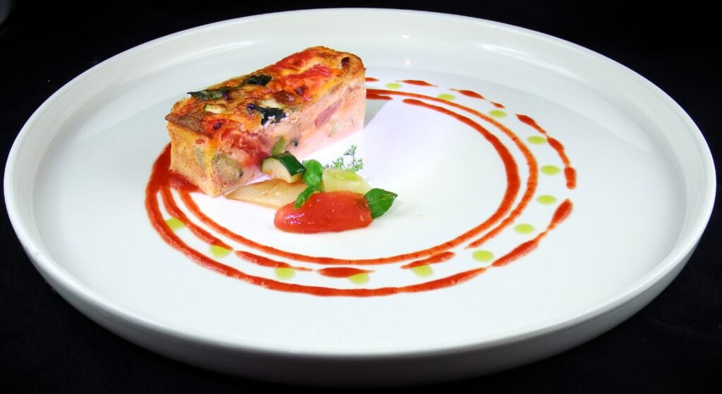 Feines Gericht mit Tomate, Basilikum und dekorativer Sauce, "Biochef" Istvan Varga.